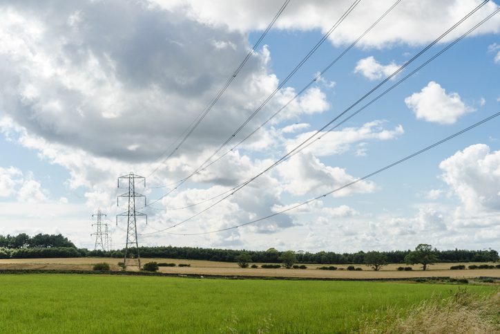 Image of a row of electricity pylons in green fields